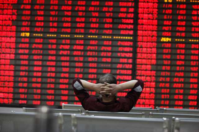 Investor watchs electric board in a stock market. China fund. Chinese equities.